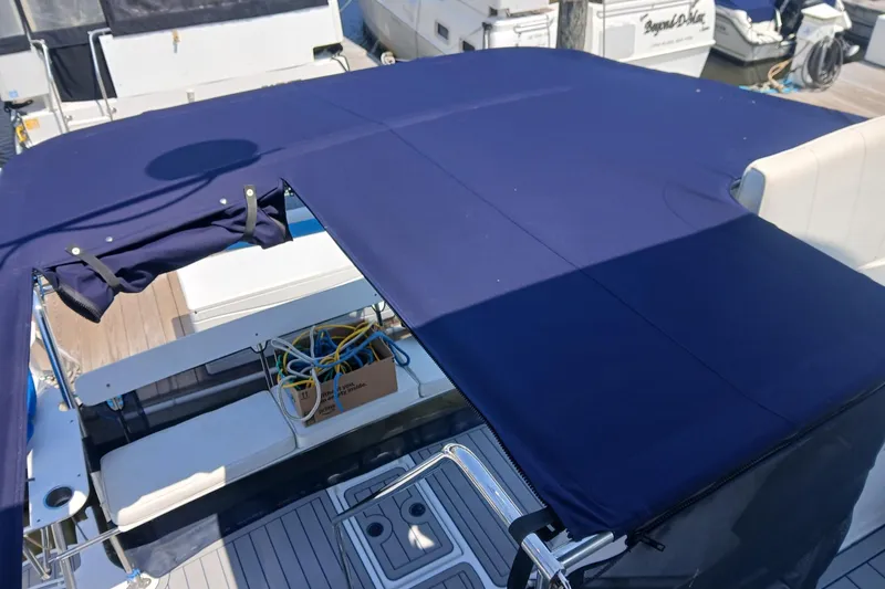 Slide: The Image of 2006 PDQ PowerCat boat with blue canopy and docked at marina. - 24