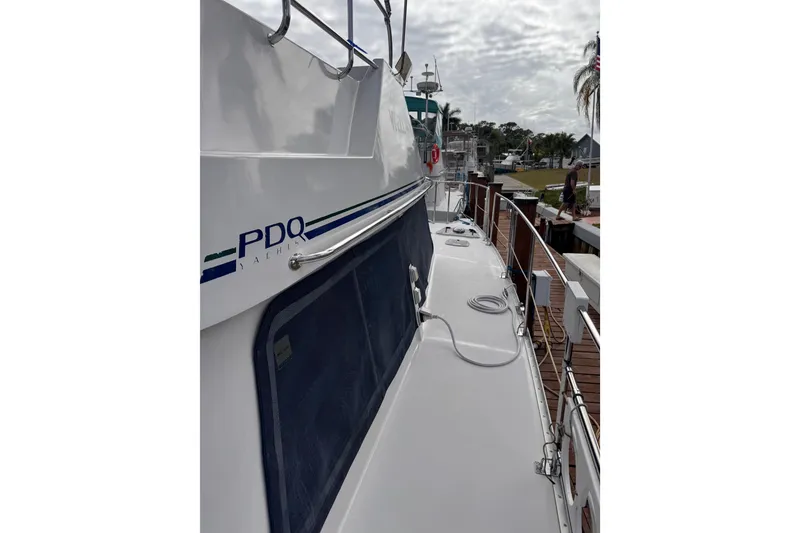 Slide: The Image of 2006 PDQ PowerCat yacht docked, showcasing sleek design and railing details. - 29