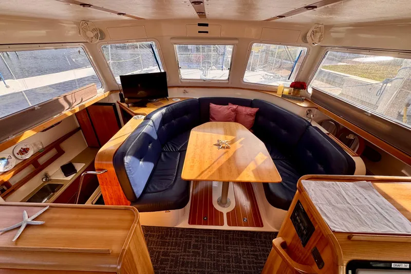 Slide: The Image of Interior of 2006 PDQ PowerCat with cozy seating, wooden table, and large windows. - 3