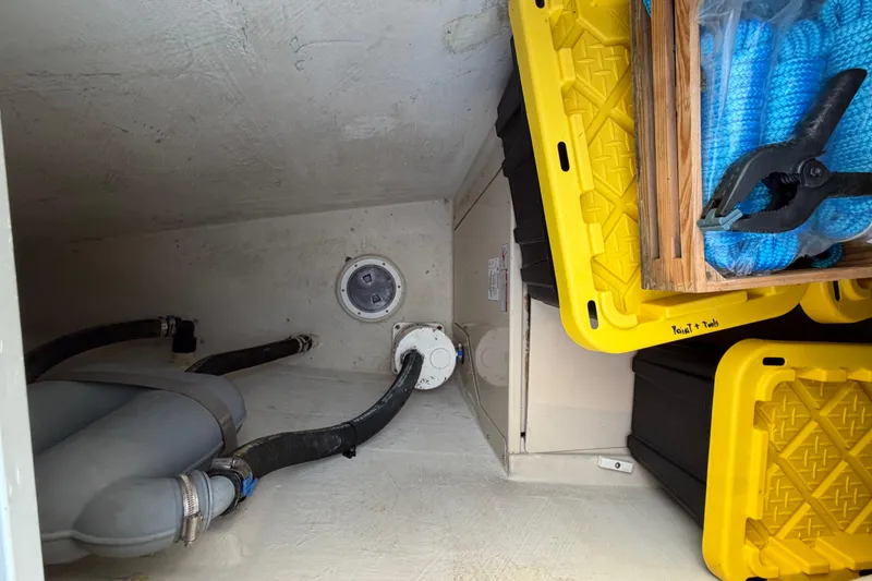 Slide: The Image of Storage compartment of 2006 PDQ PowerCat with hoses, yellow bins, and tools. - 31