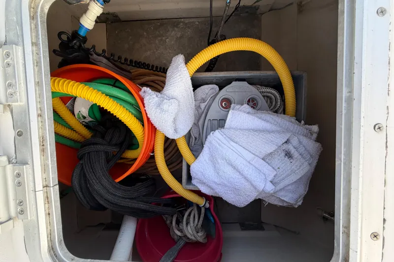 Slide: The Image of Storage compartment of 2006 PDQ PowerCat with hoses, buckets, and towels. - 33