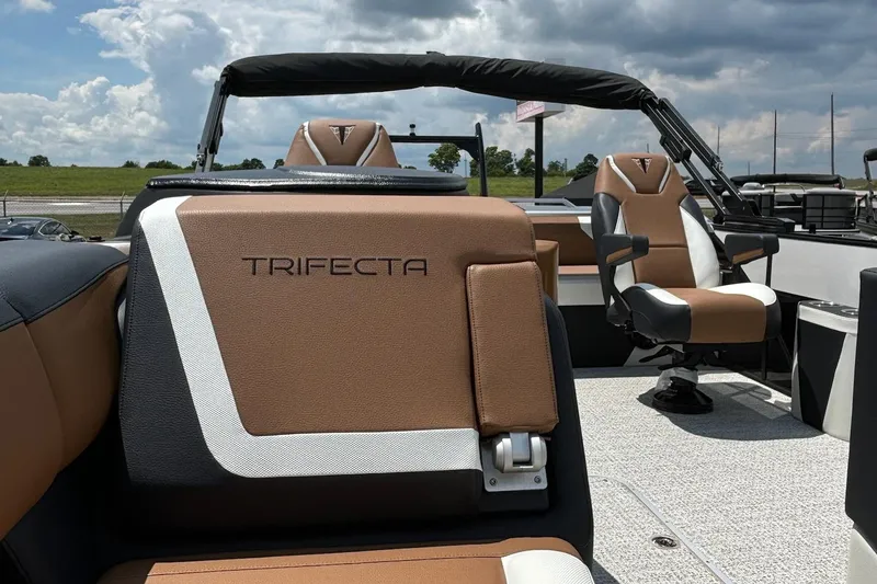 Slide: The Image of 2026 Trifecta 23 ULE SS boat interior with brown and white seating under a cloudy sky. - 5