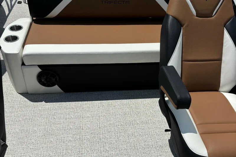 Slide: The Image of 2026 Trifecta 23 ULE SS boat interior with brown and white seating, cup holders, and speaker. - 6