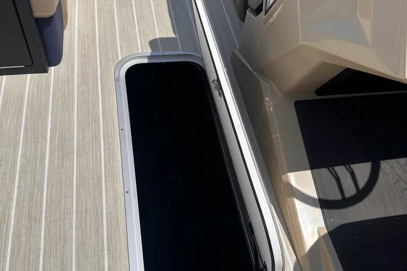 Slide: The Image of Open storage compartment on Trifecta 23 ULE SS boat, 2026 model, with beige flooring. - 14