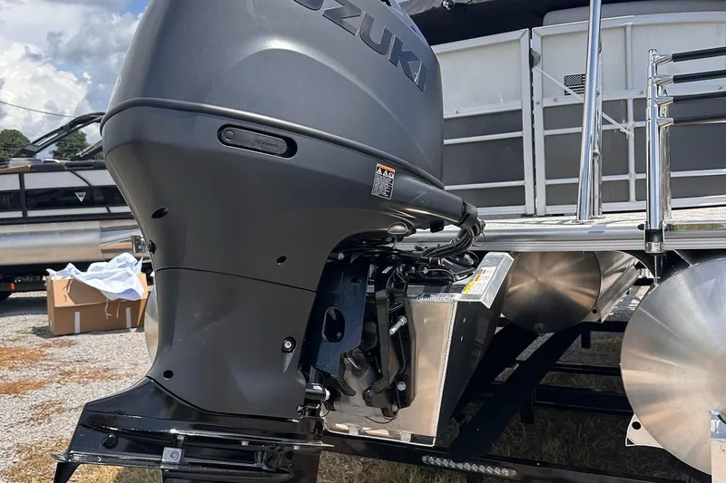 Slide: The Image of 2026 Trifecta 22 RF LE pontoon boat with Suzuki outboard motor, docked outdoors. - 11