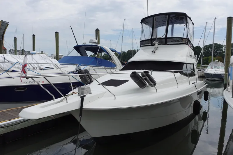 The Image of 1993 Silverton 31 Convertible yacht docked at marina, featuring sleek design and spacious deck. - 0