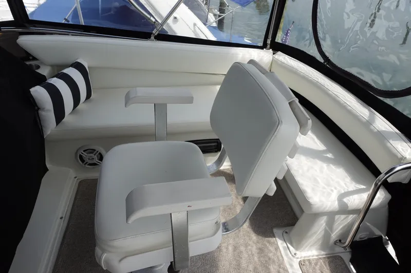 Slide: The Image of Interior of 1993 Silverton 31 Convertible boat with white seating and striped pillow. - 11