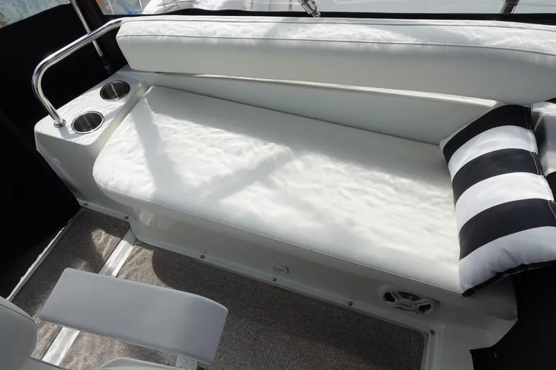 Slide: The Image of 1993 Silverton 31 Convertible boat interior with white seating and striped pillow. - 13
