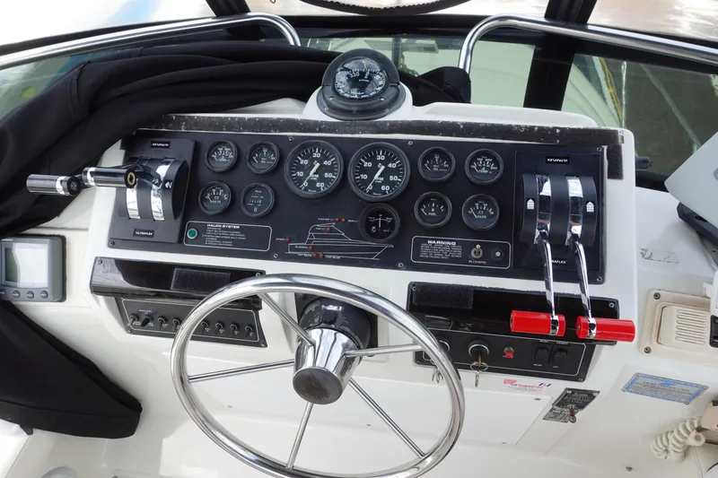 Slide: The Image of 1993 Silverton 31 Convertible boat dashboard with steering wheel and control panel. - 15