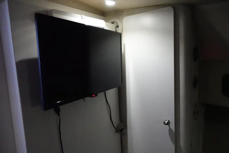 Slide: The Image of 1993 Silverton 31 Convertible interior with mounted TV and white door. - 25