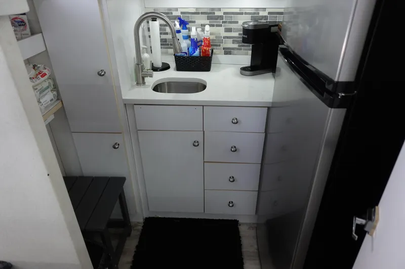 Slide: The Image of Compact kitchen area in a 1993 Silverton 31 Convertible boat with modern amenities. - 26