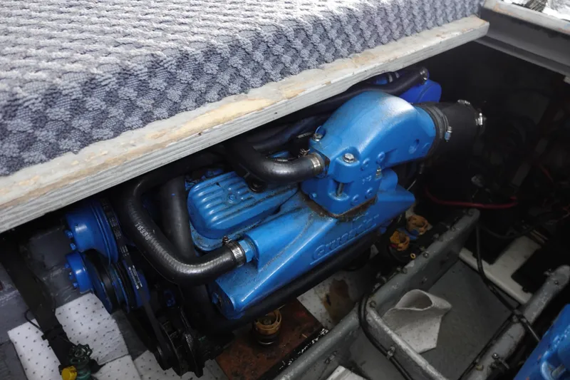 Slide: The Image of Engine compartment of a 1993 Silverton 31 Convertible boat, featuring a blue engine. - 32