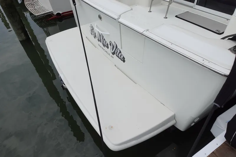 Slide: The Image of 1993 Silverton 31 Convertible boat docked, rear view with swim platform. - 5
