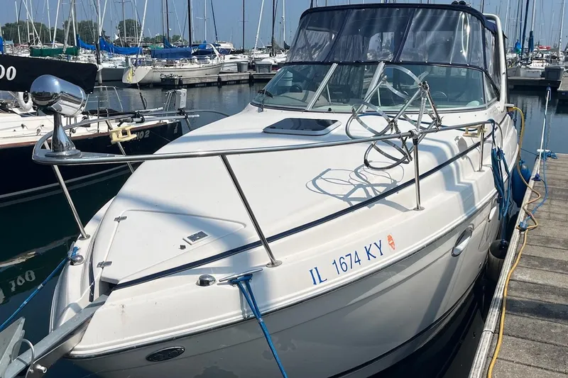 The Image of 2004 Rinker Fiesta Vee 270 boat docked in a marina, clear day, calm water. - 0