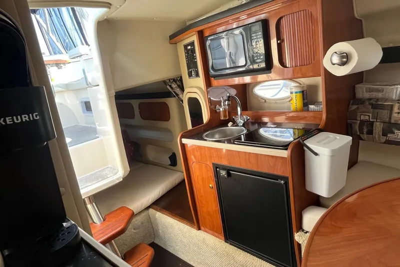 Slide: The Image of 2004 Rinker Fiesta Vee 270 boat interior with a stainless steel drawer and colorful plate. - 11