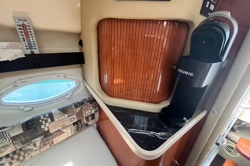 Slide: The Image of 2004 Rinker Fiesta Vee 270 cabin interior with Keurig coffee maker and porthole window. - 14