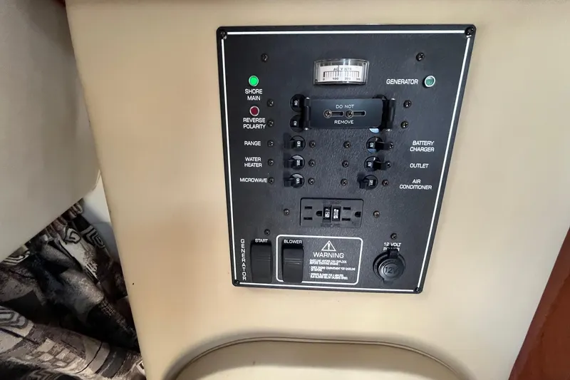 Slide: The Image of Control panel of a 2004 Rinker Fiesta Vee 270 boat, featuring various switches and indicators. - 16