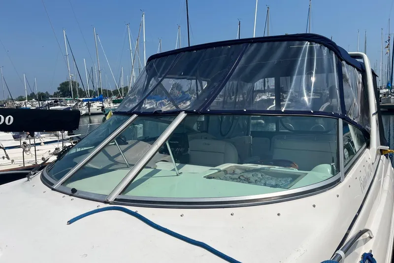 Slide: The Image of 2004 Rinker Fiesta Vee 270 boat interior with seating and table, docked at marina. - 2