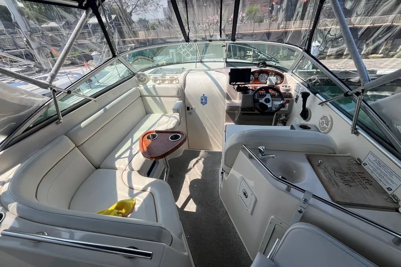 Slide: The Image of 2004 Rinker Fiesta Vee 270 boat interior with seating, table, and nautical decor. - 9