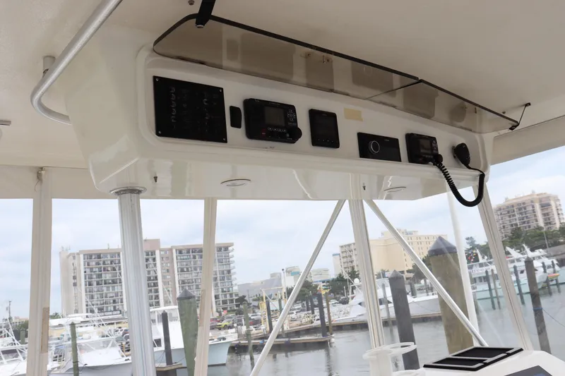 Slide: The Image of 2004 Ocean Yachts 43 Super Sport helm with control panel, marina view in background. - 14