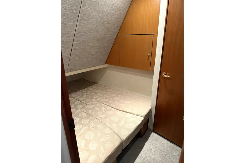 Slide: The Image of 2004 Ocean Yachts 43 Super Sport cabin with cozy bed and wooden storage. - 29