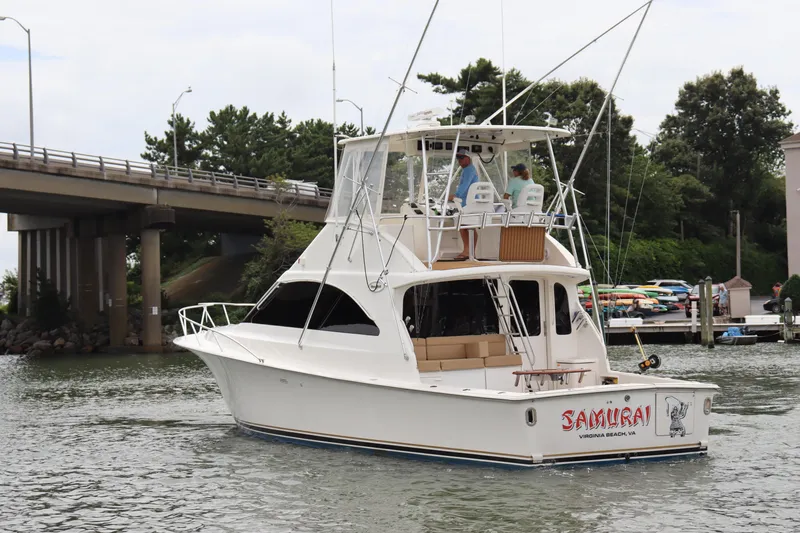 Slide: The Image of 2004 Ocean Yachts 43 Super Sport boat cruising near a bridge and marina. - 3