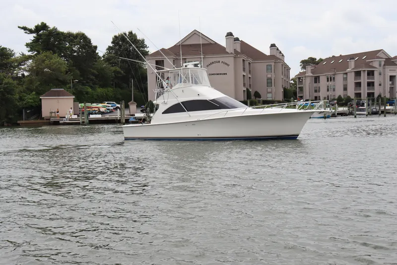 The Image of 2004 Ocean Yachts 43 Super Sport boat docked near waterfront condominiums. - 1