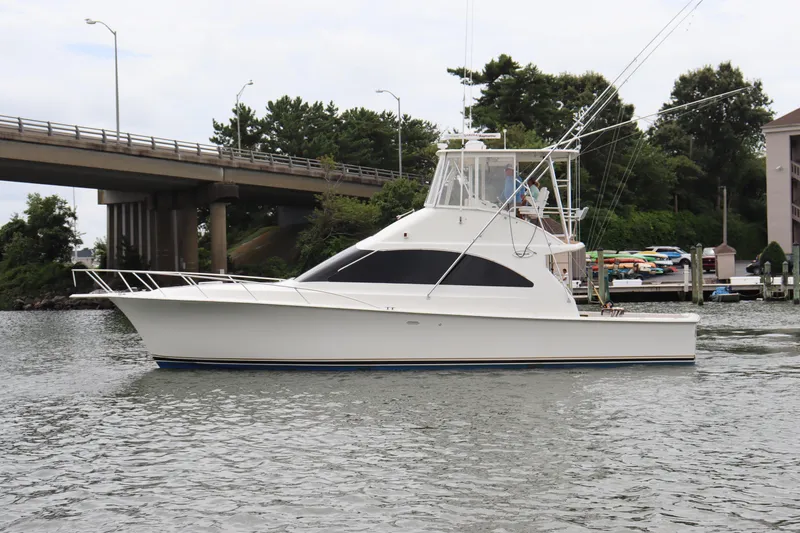 Slide: The Image of 2004 Ocean Yachts 43 Super Sport cruising on a calm river near a bridge. - 2