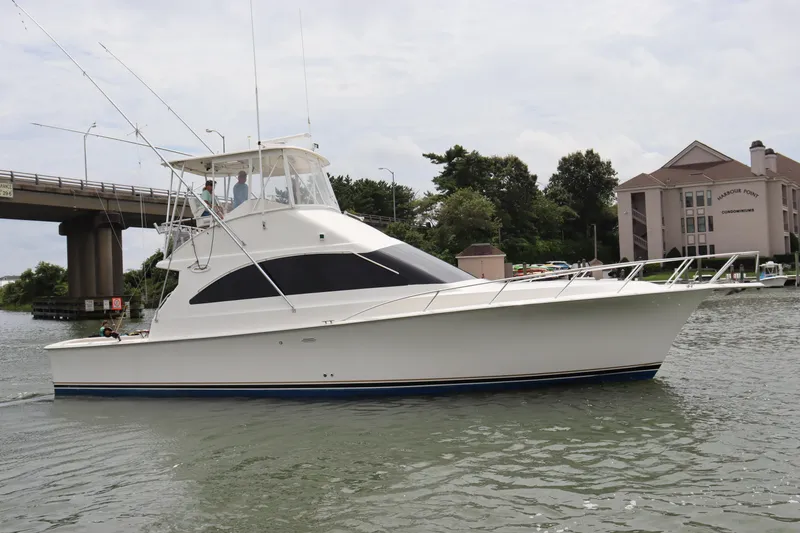 Slide: The Image of 2004 Ocean Yachts 43 Super Sport cruising near a bridge and waterfront buildings. - 4