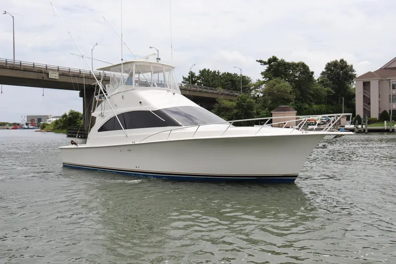 Slide: The Image of 2004 Ocean Yachts 43 Super Sport cruising on a calm waterway near a bridge. - 5