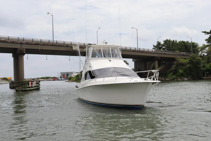 Slide: The Image of 2004 Ocean Yachts 43 Super Sport cruising under a bridge on a calm waterway. - 6