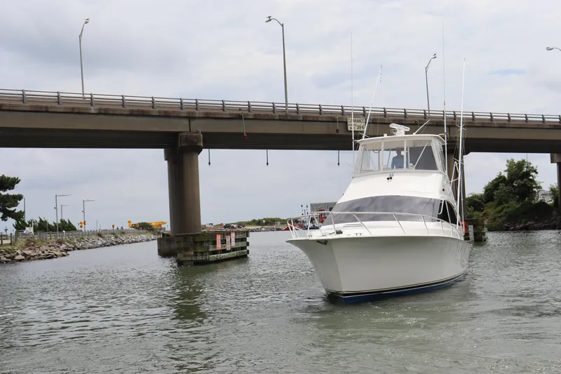 Slide: The Image of 2004 Ocean Yachts 43 Super Sport cruising under a bridge on a calm waterway. - 7
