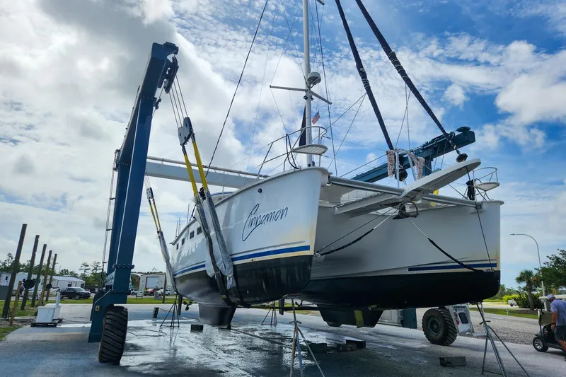 Slide: The Image of 2019 Antares 44GT catamaran lifted by crane under a cloudy sky. - 18