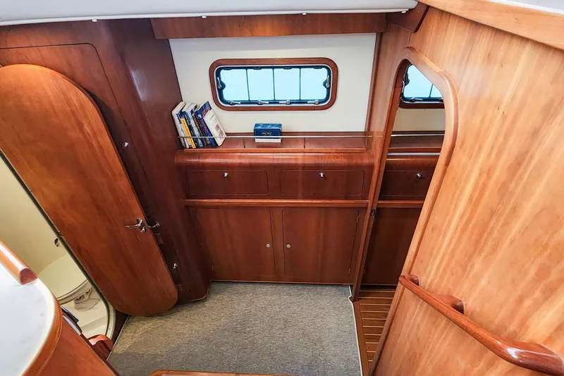 Slide: The Image of Interior of 2019 Antares 44GT yacht with wooden cabinetry and books on a shelf. - 39