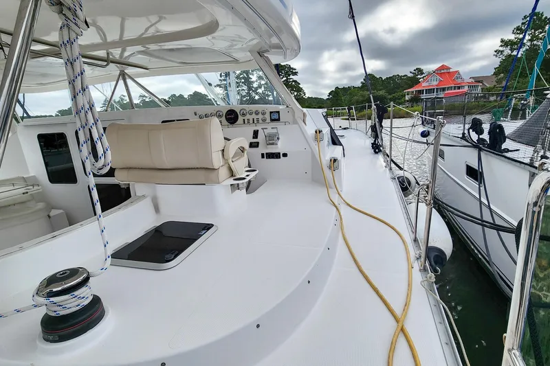 Slide: The Image of 2019 Antares 44GT yacht deck with helm, moored by waterfront homes. - 4