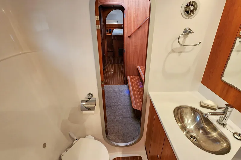 Slide: The Image of Antares 44GT 2019 yacht bathroom with sink, toilet, and wooden interior. - 46