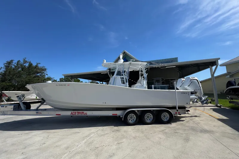 Slide: The Image of 2025 Conch 33 boat on trailer under clear blue sky. - 1