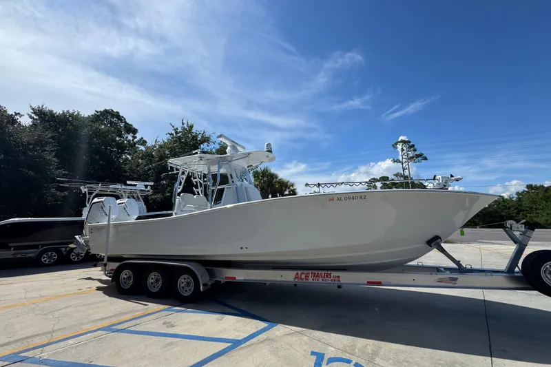 Slide: The Image of 2025 Conch 33 boat on trailer under clear blue sky. - 10
