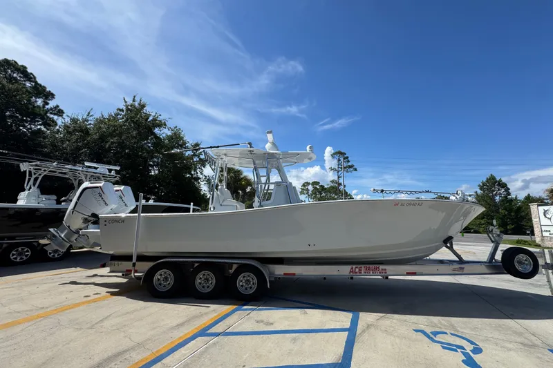 Slide: The Image of 2025 Conch 33 boat on trailer under clear blue sky. - 11
