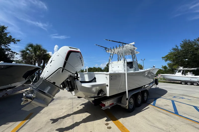 Slide: The Image of 2025 Conch 33 boat on trailer with powerful outboard motor, parked outdoors. - 14