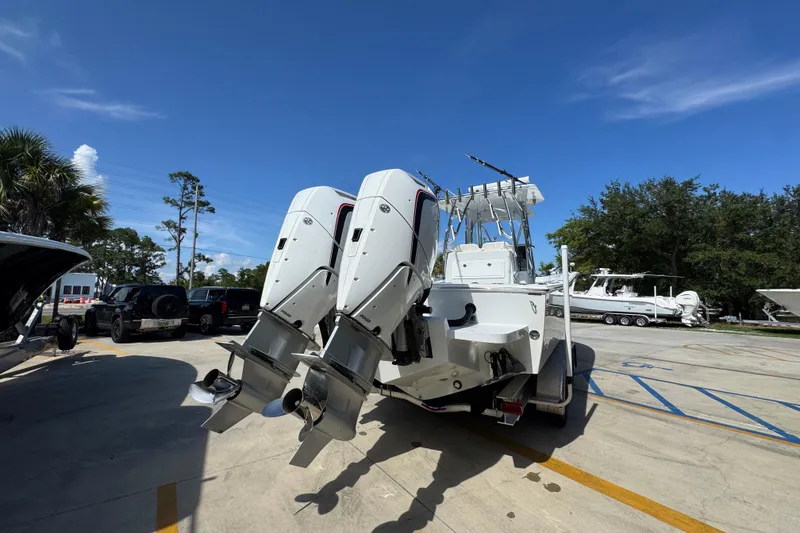 Slide: The Image of 2025 Conch 33 boat with dual outboard motors in a sunny marina setting. - 15