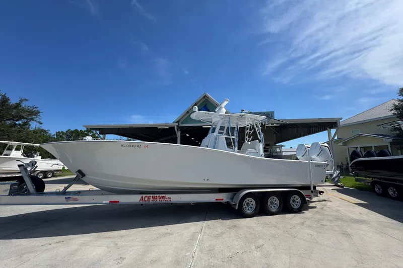 Slide: The Image of 2025 Conch 33 boat on trailer under clear blue sky. - 2
