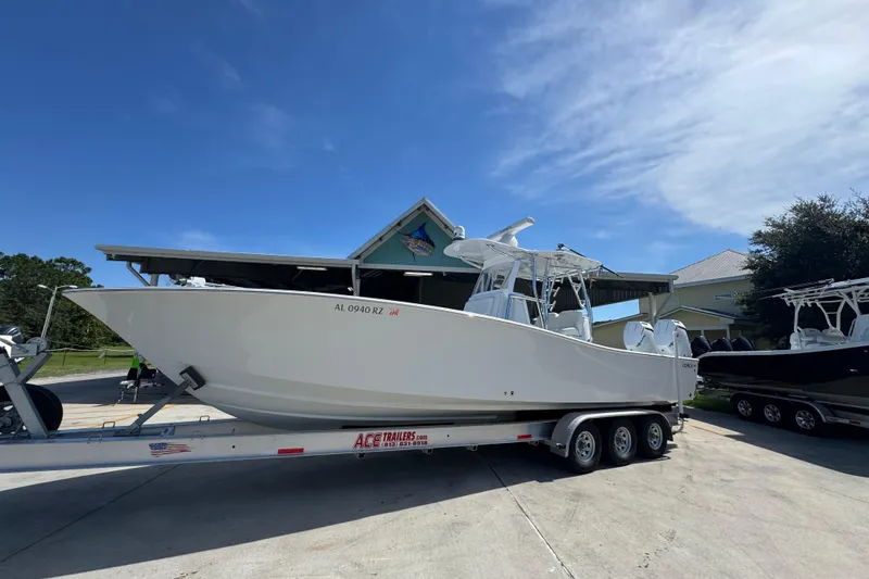 Slide: The Image of 2025 Conch 33 boat on trailer under clear blue sky. - 3