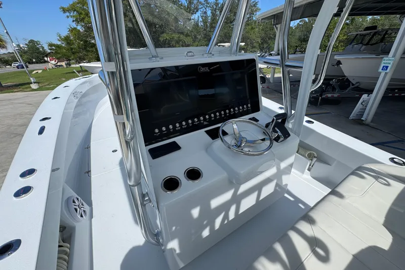 Slide: The Image of 2025 Conch 33 boat console with steering wheel and control panel in a marina setting. - 34