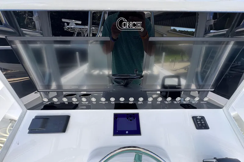 Slide: The Image of Control panel of 2025 Conch 33 boat with modern navigation displays and controls. - 36