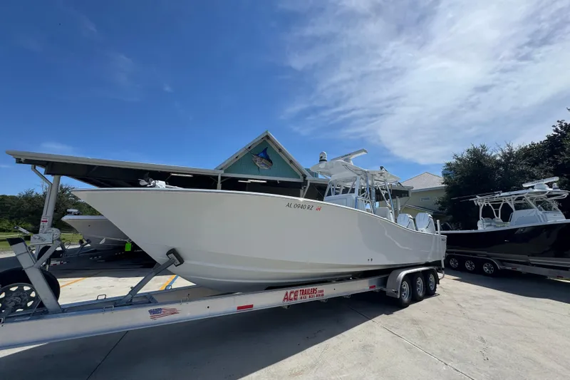 Slide: The Image of 2025 Conch 33 boat on trailer under clear blue sky. - 4