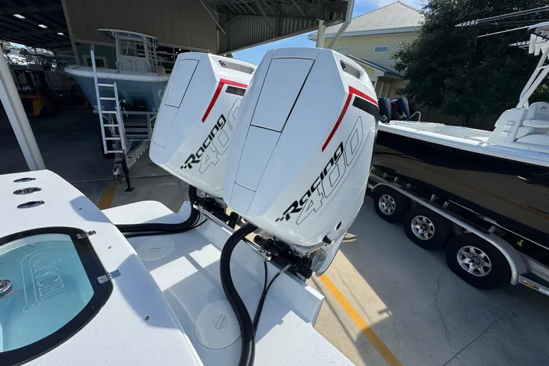 Slide: The Image of 2025 Conch 33 boat with dual Racing 400 outboard engines in a marina setting. - 44