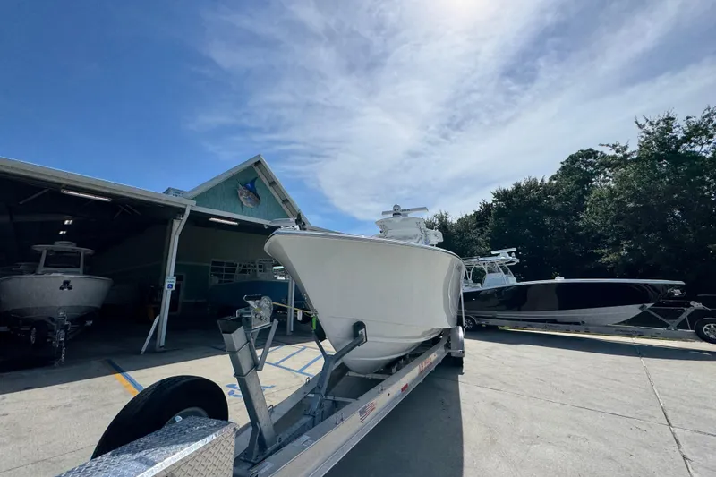 Slide: The Image of 2025 Conch 33 boat on trailer outside a marina under a clear blue sky. - 6