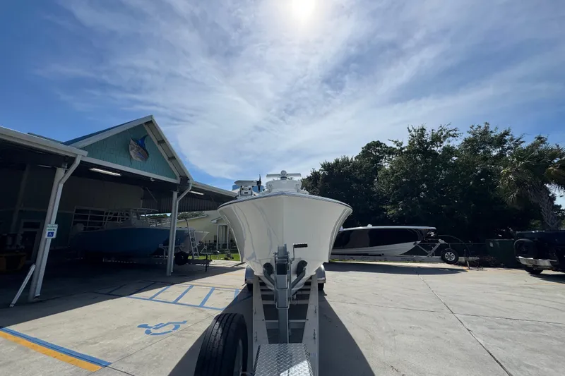 Slide: The Image of 2025 Conch 33 boat on trailer under sunny sky at marina. - 7