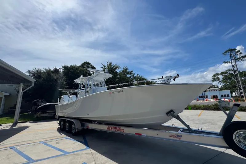Slide: The Image of 2025 Conch 33 boat on trailer under clear blue sky. - 9
